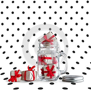 Mason jar filled with small gift boxes.