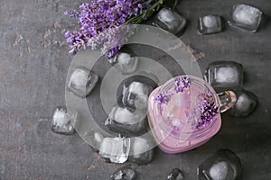 Mason jar with lavender lemonade and ice cubes on grey background