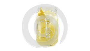 Mason jar with lemonade and ice on white background. Macro photo.