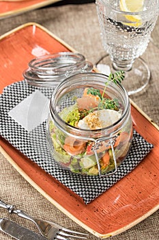 Mason jar with salmon, cucumber and cream cheese salad on the table at restaurant