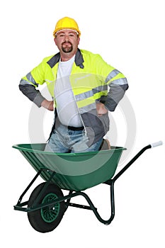 Mason kneeling in wheelbarrow