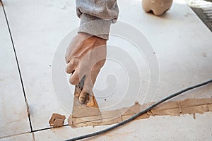 Mason passing the paste in the joint between tiles. I work in a construction