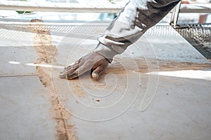 Mason passing the paste in the joint between tiles. I work in a construction