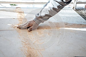 Mason passing the paste in the joint between tiles. I work in a construction