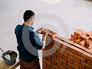 Mason Placing Brick on Wall Indoors
