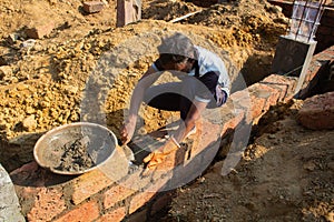 Mason Spreading Cement While Building Brick Foundation