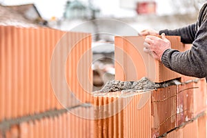 Mason worker bricklayer installing brick walls