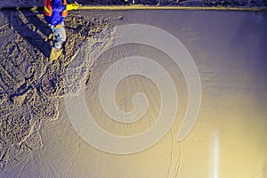 Mason worker leveling concrete with trowels, mason hands spreading poured concrete. Concreting workers are leveling poured liquid