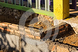 Masoned wall made of red/orange bricks and mortar