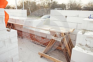 Masonry. Laying autoclaved aerated concrete blocks with reinforcement and adhesive. Installing white blocks close up. Process of