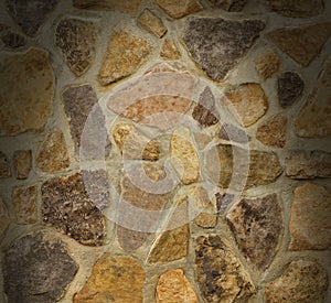 Masonry wall with irregular stones lit from above