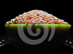 Masoor dal, lentil, legumes in a green pot in dark background