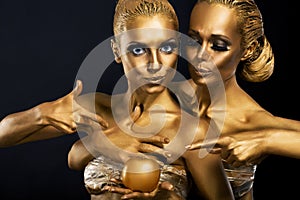 Masquerade. Enjoyment. Two Glossy Women with Golden Body Art. Glamor