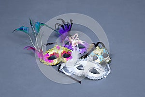 Masquerade masks with feathers on gray background