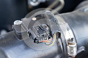 Mass air flow MAF sensor under the open hood of a car