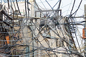 A mass of tangled utility wires above the streets of Delhi, India.