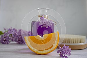 Massage brush, cream, lilac flower,  concept on a light moisturizer moisturizer