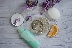 Massage brush, cream, lilac flower,  relaxation on a light moisturizer moisturizer