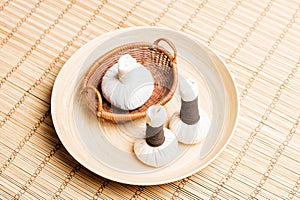 Massage bundles on a plate on a bamboo mat