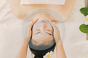 Massage the head of an Asian woman in the spa salon