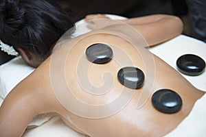 Massage with hot black stone by therapists