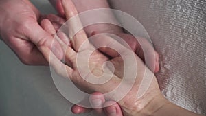 The massage on the palm . Masseur doing massage on the palm of a young girl.