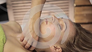 Massage scraper gouache. masseur makes acupressure on a female face. Chinese alternative medicine