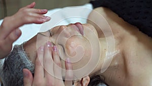 Massage therapist is doing manual massage on client`s face. Facial beauty treatment. Spa facial massage