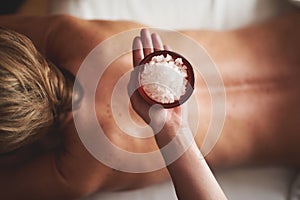 Massage therapist hold bowl with salt in hand
