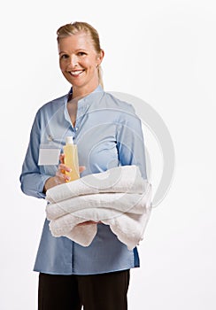 Massage therapist holding oil and towels