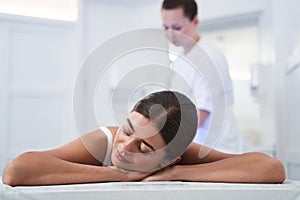 Massage therapist massaging shoulders of woman