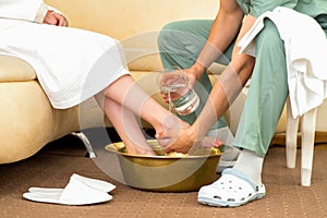 Massage therapist washes the woman`s feet the massage salon