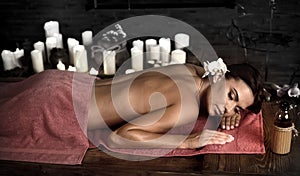 Massage woman back in beauty spa with candlelight