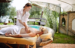 Massage - woman receiving back massage at salon spa