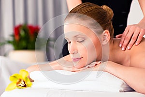 Massager giving woman wellness spa massage