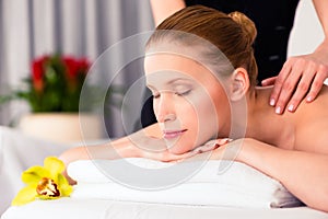 Massager giving woman wellness spa massage photo