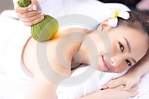 Massager rejuvenate and massage charming beautiful womanâ€™s back by using herbal ball. Attractive girl feels relaxed and happy.