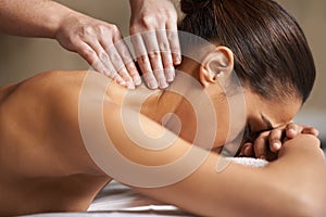 Massaging away all the worries and stress. a young woman enjoying a back massage at a spa.