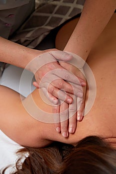 Massagist performing back massage to female client