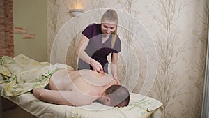 The masseur does back massage to the male patient. Massage.