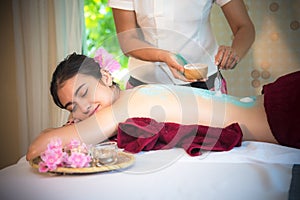 Masseur doing massage spa with treatment sugar scrub on Asian woman body in the Thai spa lifestyle, so relax and luxury.