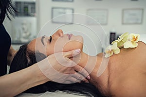 masseur doing therapeutic acupressure massage neck her female client in spa centre