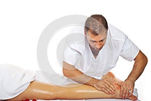 Masseur give therapeutic massage to woman legs
