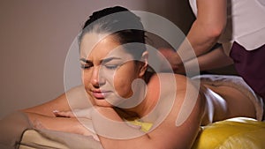 Masseur knocks hands on the girl back. The girl is in pain. She stares blankly at the camera. 4K Slow Mo