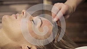 Masseur makes acupressure on a female face. Chinese alternative massage with scraper gouache