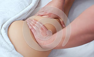 The masseur makes Anti-cellulite massage on the buttock and thighs of the patient.