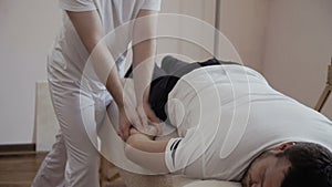 Masseur makes massage of hand to the man