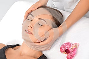 Masseur makes a relaxing massage on the face, neck, shoulders and collarbones of a young beautiful woman in a spa. Cosmetology and