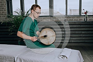 Masseur man holding a tambourine in the sleeve.