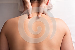 masseur massaging back and shoulder blades of young woman on massage table. Concept of massage spa treatments. Close-up